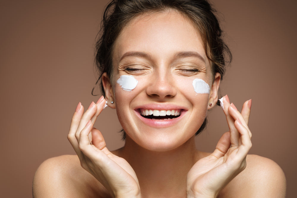 smiling woman with moisturizer on face